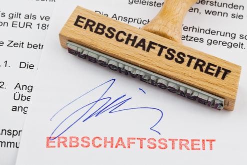 Stempel mit der Aufschrift „ERBSCHAFTSTREIT“ auf einem Dokument mit einer blauen Unterschrift.