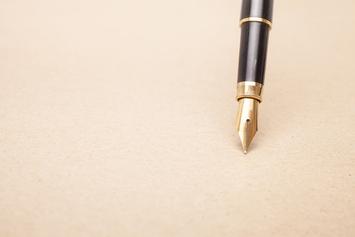 Füllfederhalter mit goldener Spitze auf braunem Papier.